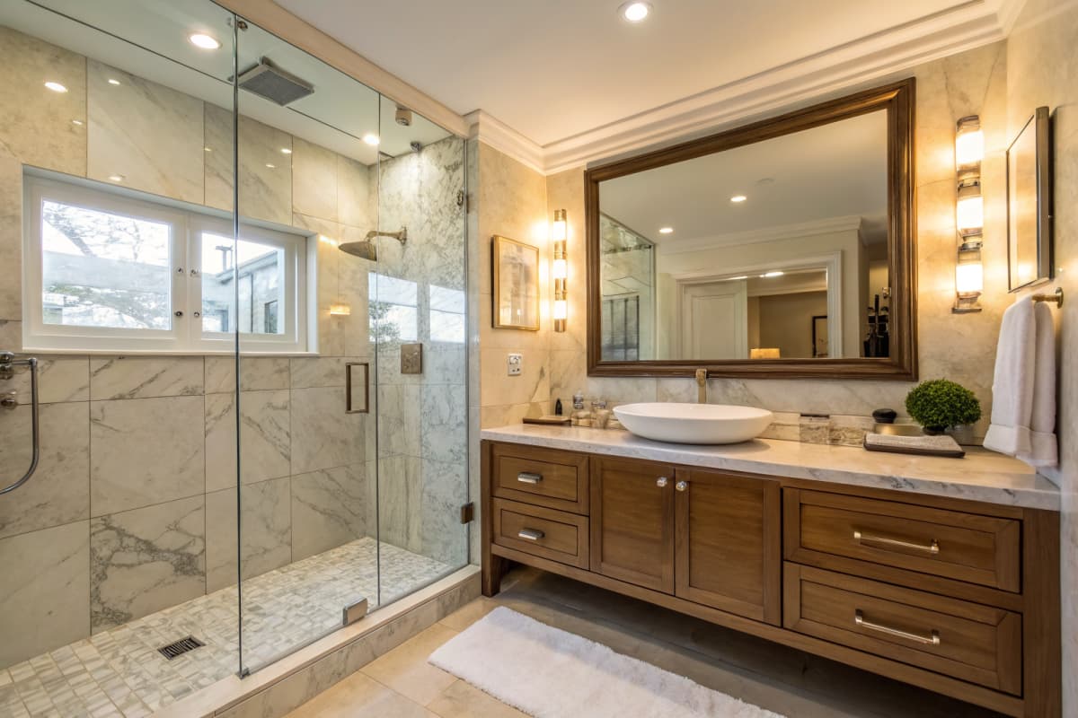 Beautifully remodeled bathroom showcasing contractor craftsmanship — marble tile and glass shower